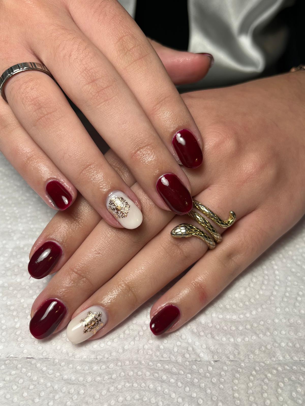 Manicure borgonha com floco de neve dourado